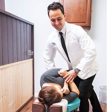Chiropractic doctor manually adjusting a patient.