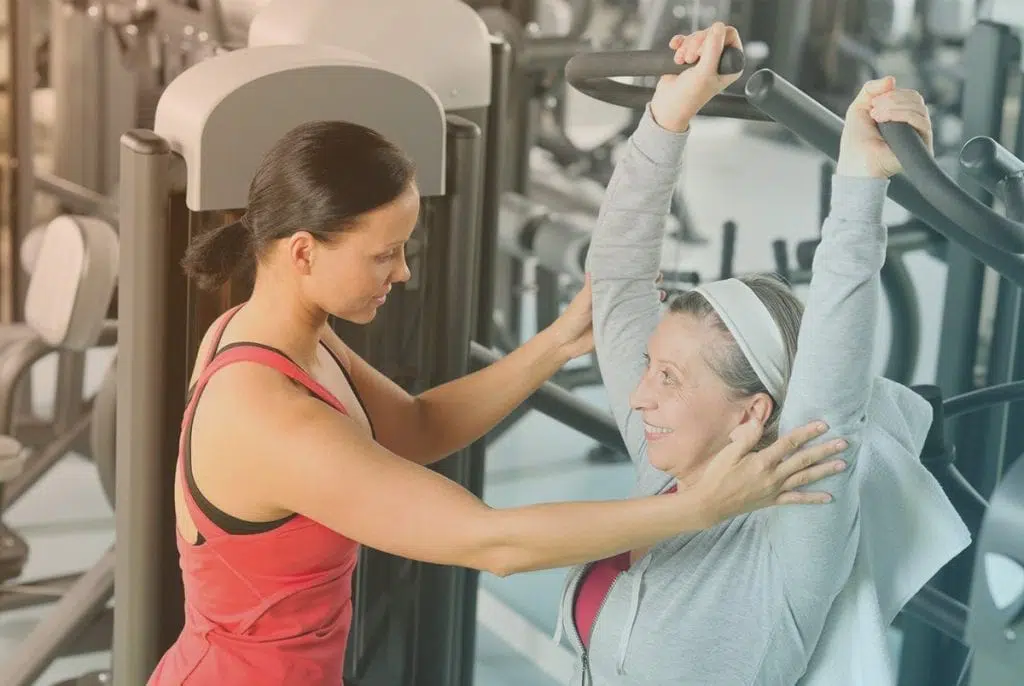 Female exercise trainer showing a patient how to perform a workout.