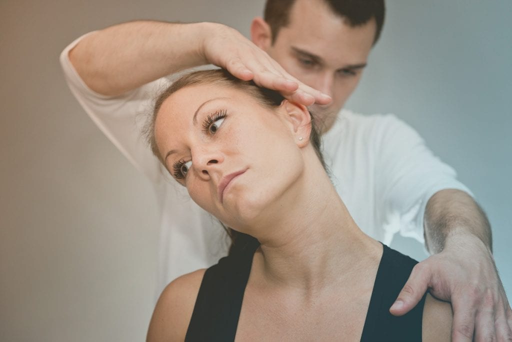 Chiropractor adjusting female patients neck