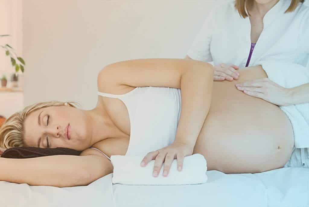 Massage therapist giving a massage to a pregnant woman