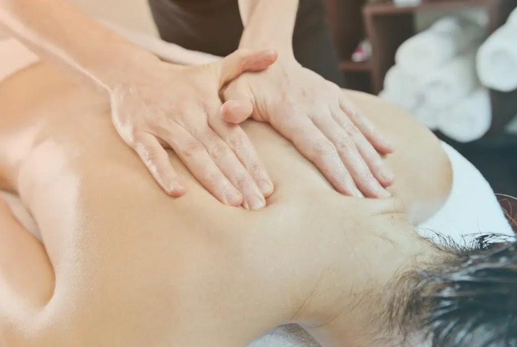 Massage therapist giving a massage to a female patient.