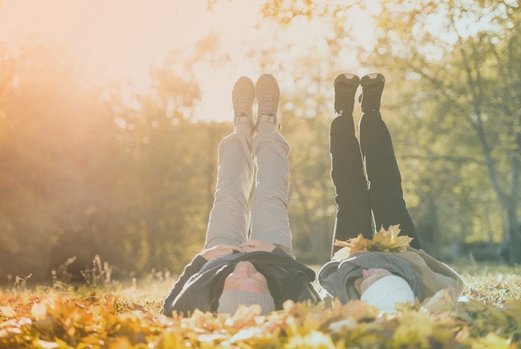 older couple laying on the ground with their feet in the air