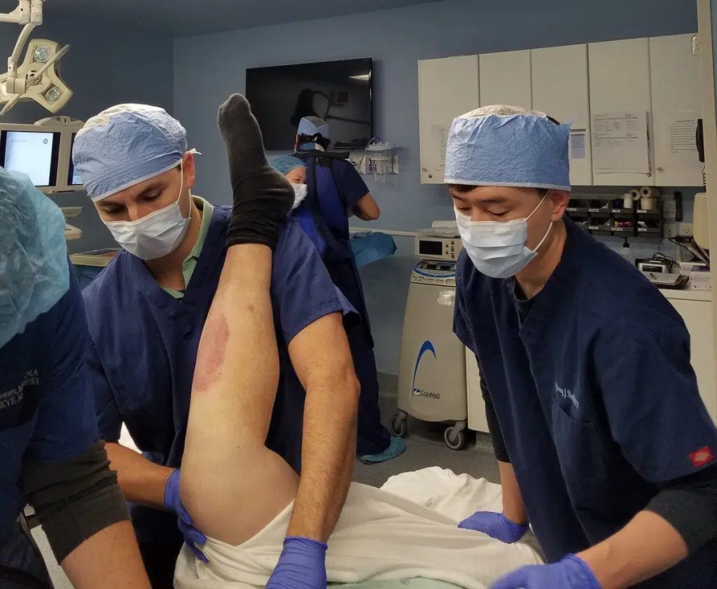 doctors helping a patient with knee pain