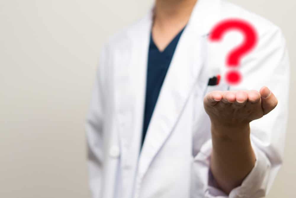 Question mark on a doctor's hand. When to get piriformis syndrome treatment?
