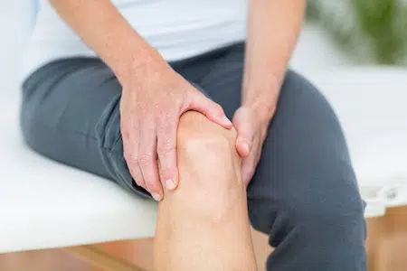 Patient holding his knee due to joint pain.