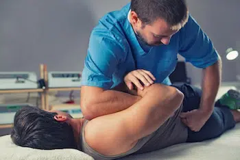 Chiropractor adjusting patients back.