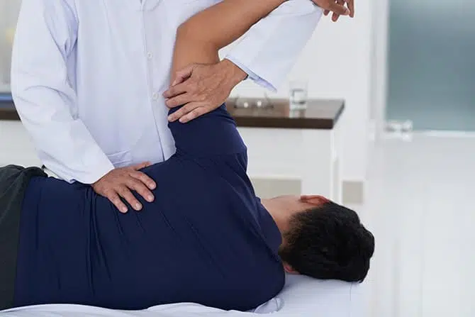 Chiropractor examining patients shoulder mobility