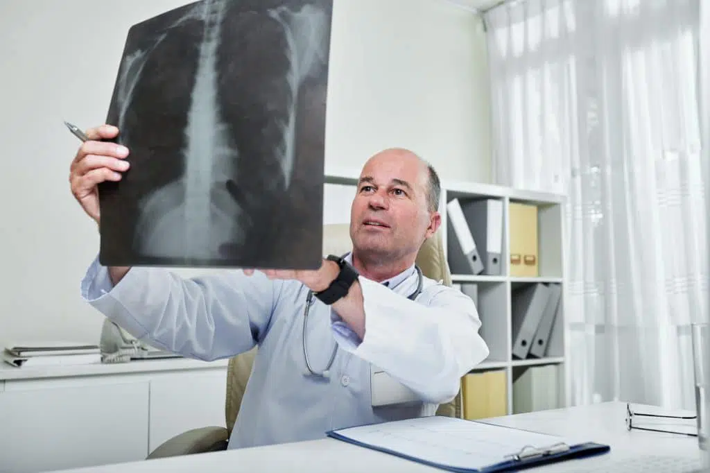 Chiropractor looking at a patients x-ray images