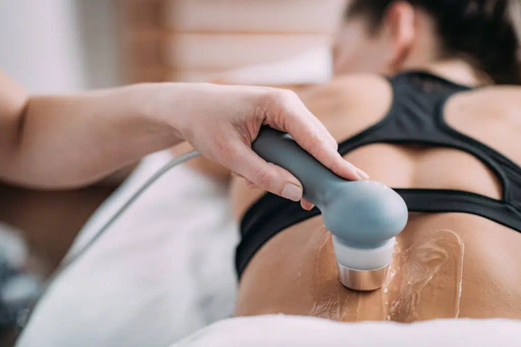 Chiropractor examining a patient with Neuromuscular ultrasound equipment