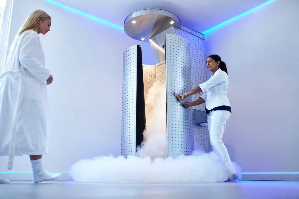 Female patient walking into a cryotherapy machine.