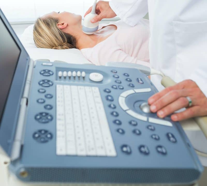 doctor scanning patients neck with an ultrasound machine
