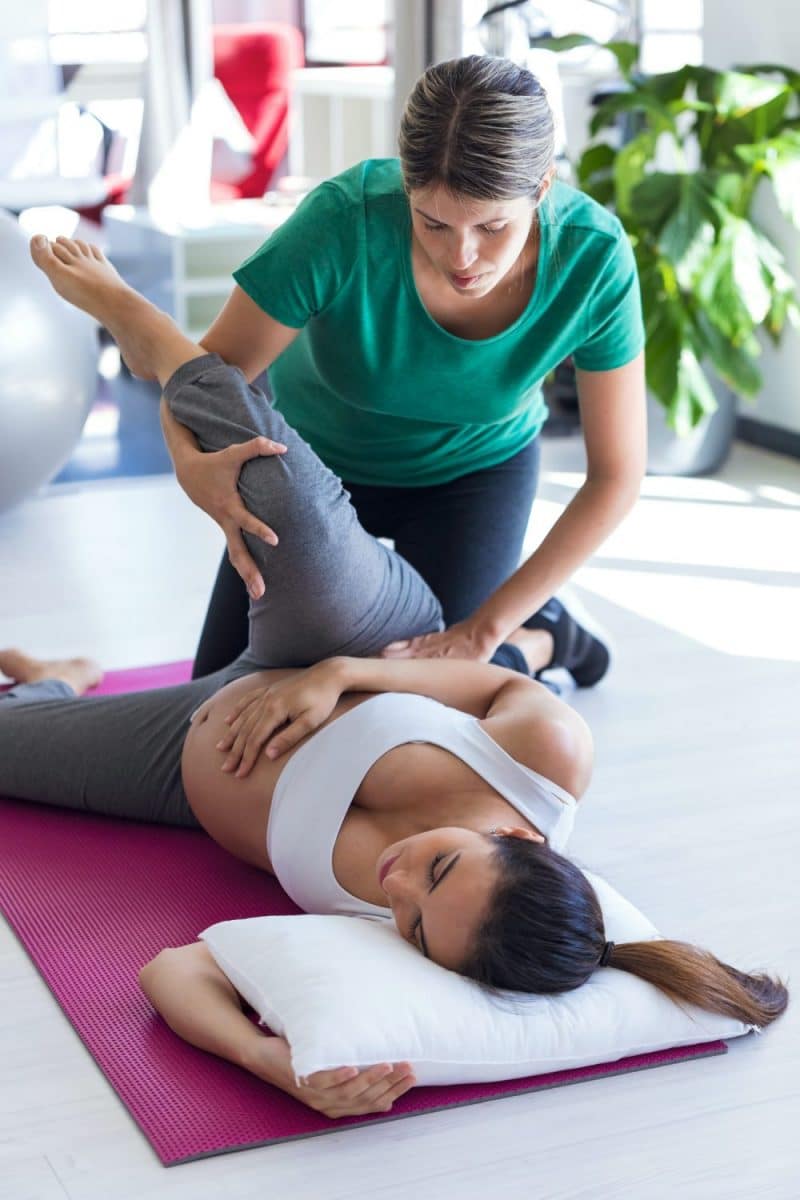 female chiropractor adjusting a pregnant woman