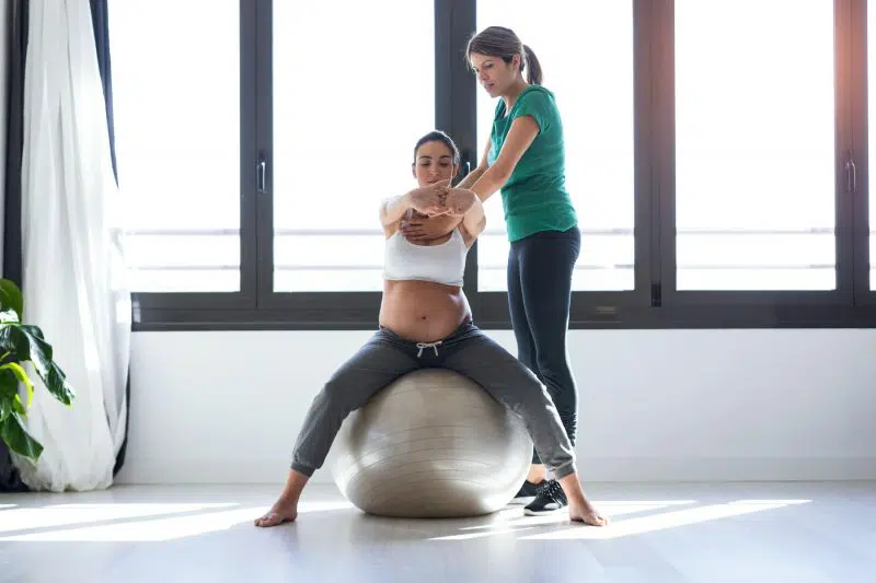 pregnant female sitting on a work out ball