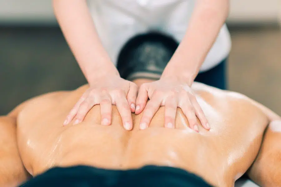 massage therapist working on a males back