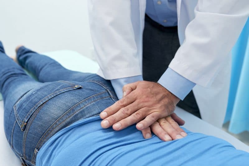 chiropractor adjusting patients spine