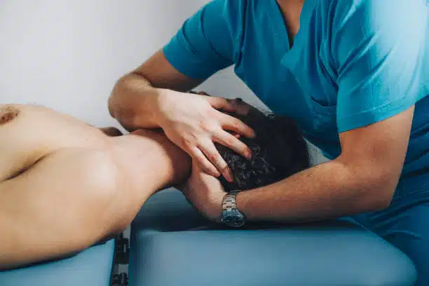 Patient is calmly lying on his back while the chiropractor is holding his neck, massaging it and adjusting it.