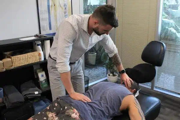 chiropractor massages patients neck, chiropractic adjustment