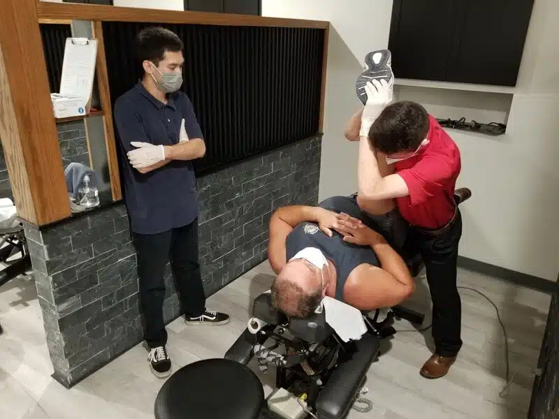 Chiropractors doing some chiropractic adjustment to the patient.