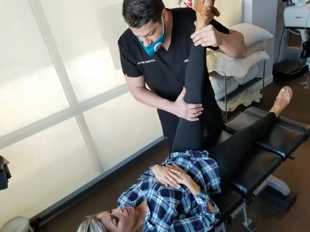 chiropractor adjusts woman's leg