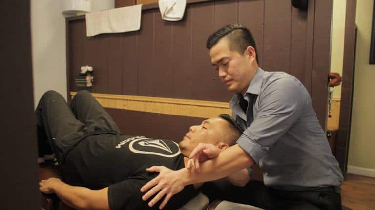 chiropractor adjusting a patient's neck