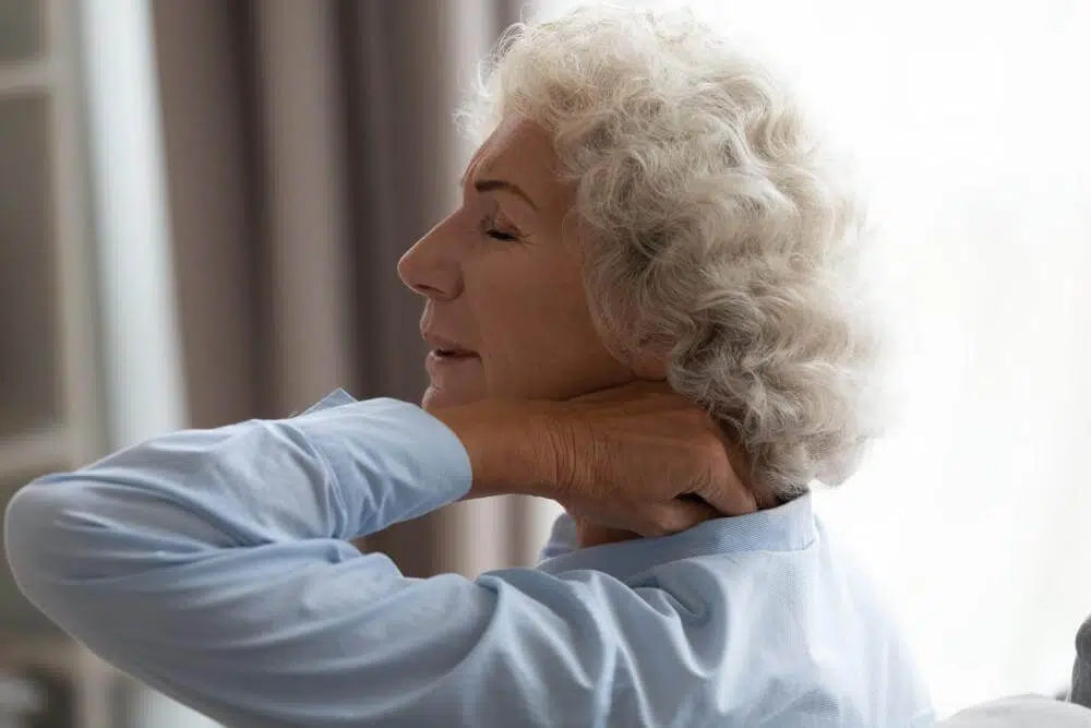 Elderly woman getting up from bed and experiencing numbness and tingling sensations