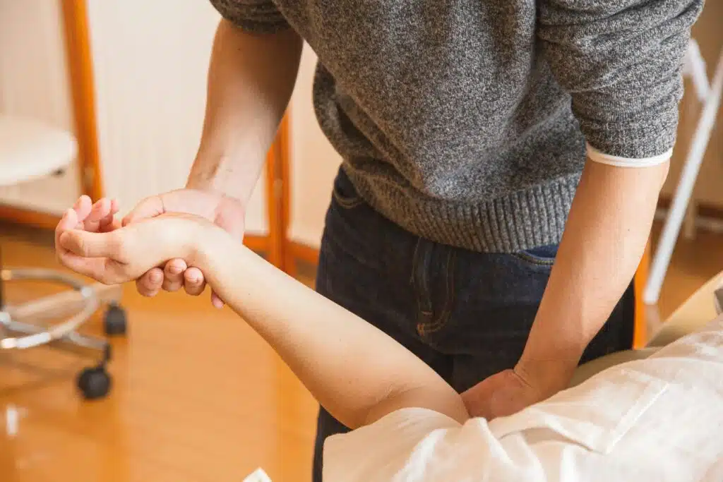 chiropractor stretching patient arms