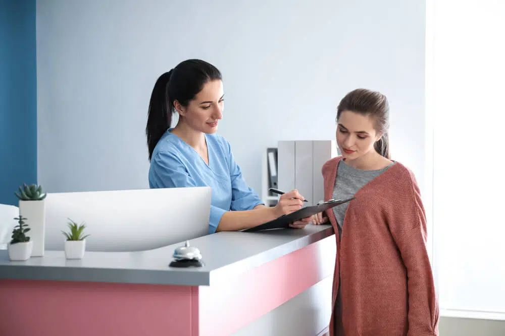 Front desk clerk explaining the United Care Health insurance to the patient