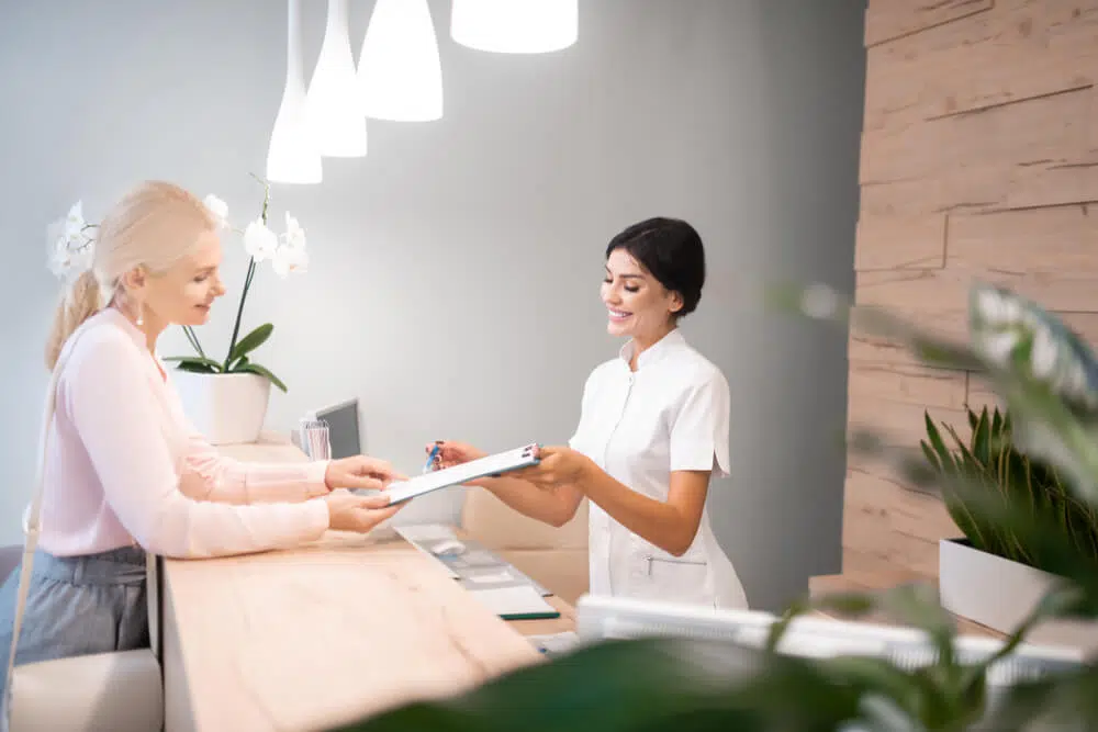 Front desk clerk explaining the  Anthem Blue Cross Health Insurance to the patient