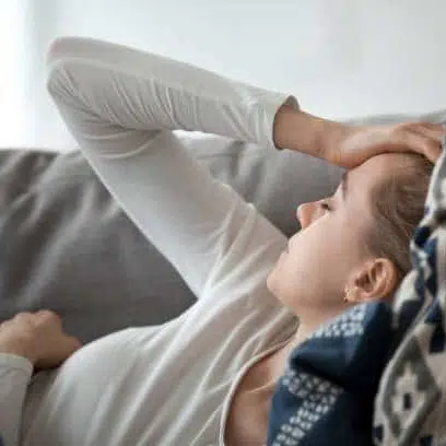 stress young woman lying on the couch  holding her head in pain