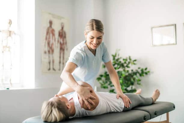 Rehabilitation physiotherapy worker with woman client suffers from worker's injury.