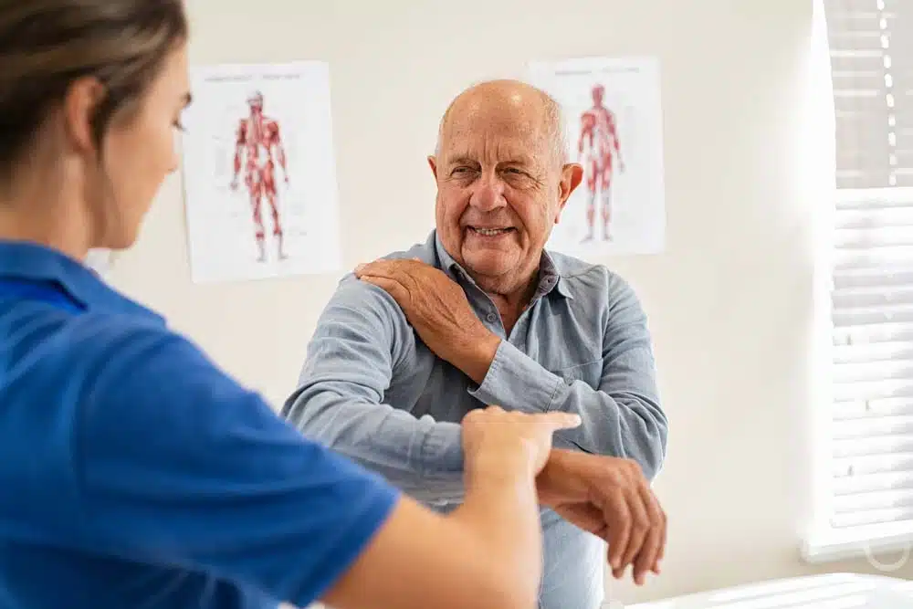 Physiotherapist doing some evaluation to an old patient suffers from frozen shoulder.