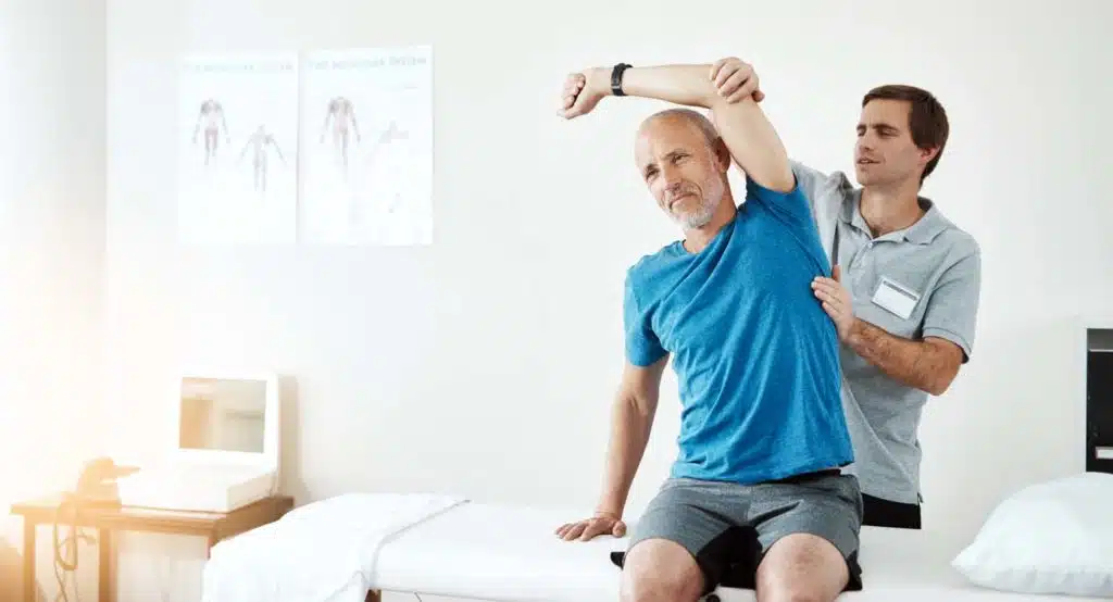 Physiotherapist helping a client with stretching exercises in his office.