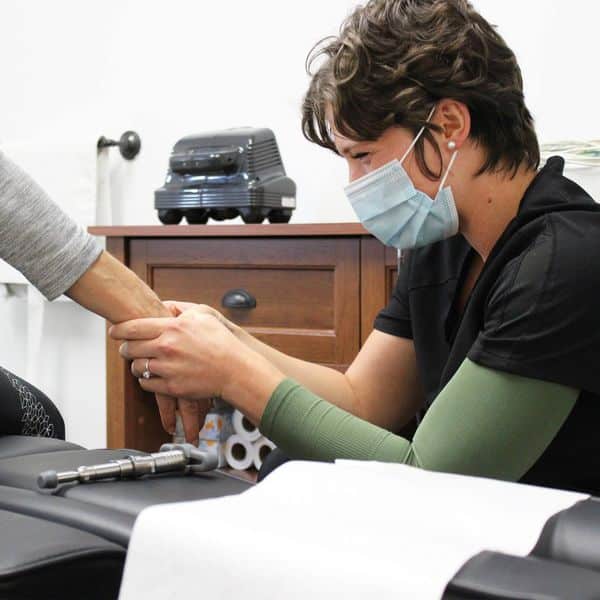 chiropractor treating a patient's hand.