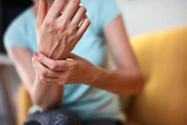 Woman with wrist and elbow pain at home suffers from Tendonitis.