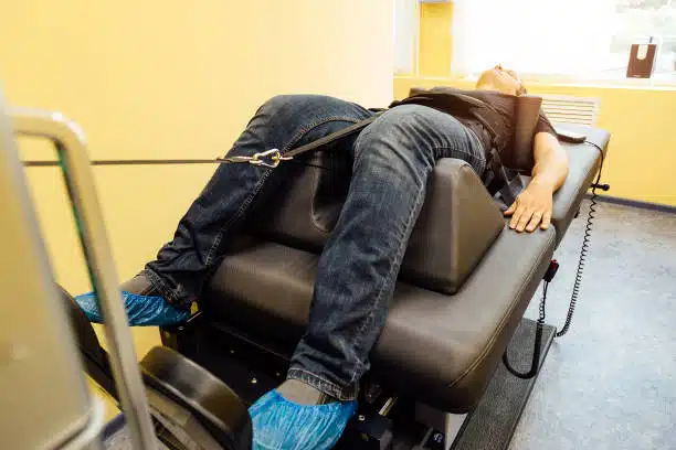 Man at non-surgical spinal decompression procedure in a chiropractic clinic.