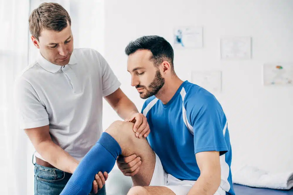 Athlete suffers from sports injuries having a treatment at chiropractic clinic.