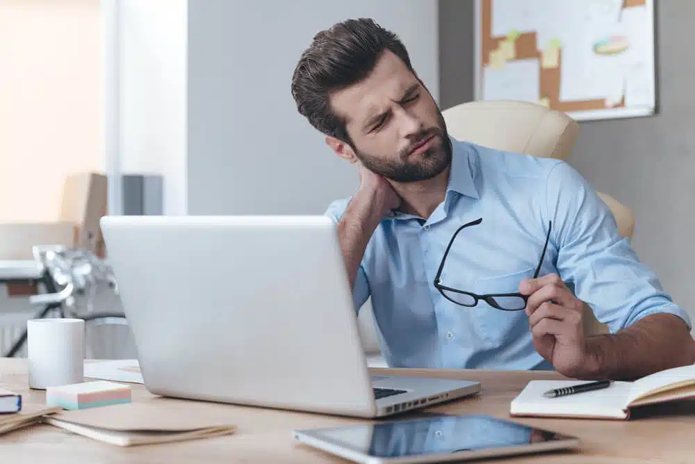 Man holding his neck feeing of too much pain caused by neck pain.