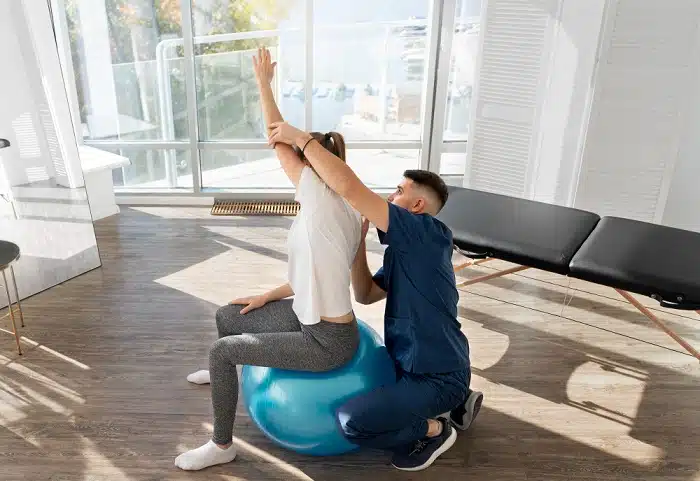 A dedicated woman at a Pilates studio in Torrance, using a stability ball to enhance her Pilates routine and improve her posture
