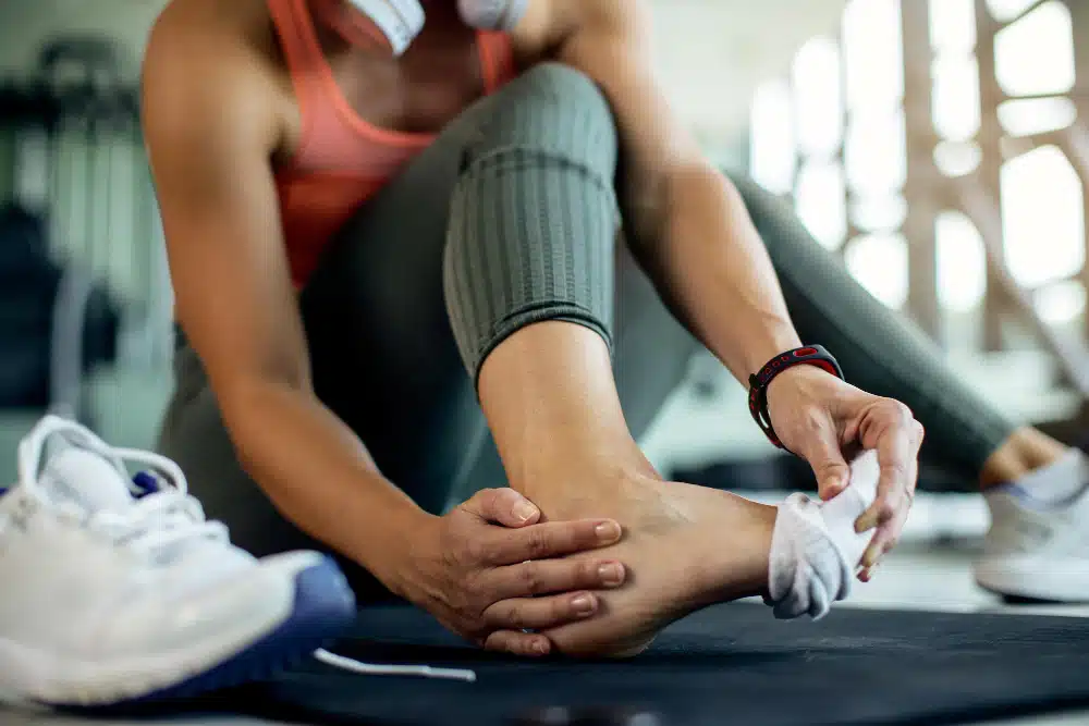 athletic woman injured her foot during workout at the gym
