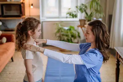Little girl doing exercise with a therapist to Pediatric Chiropractic Care