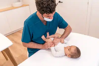 therapist giving chiropractic care to a newborn | Pediatric Chiropractic Care