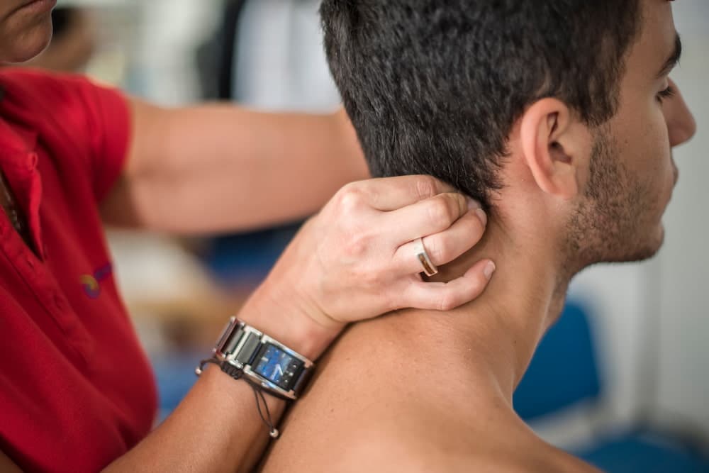 chiropractor pressing patient's neck for neck pain relief