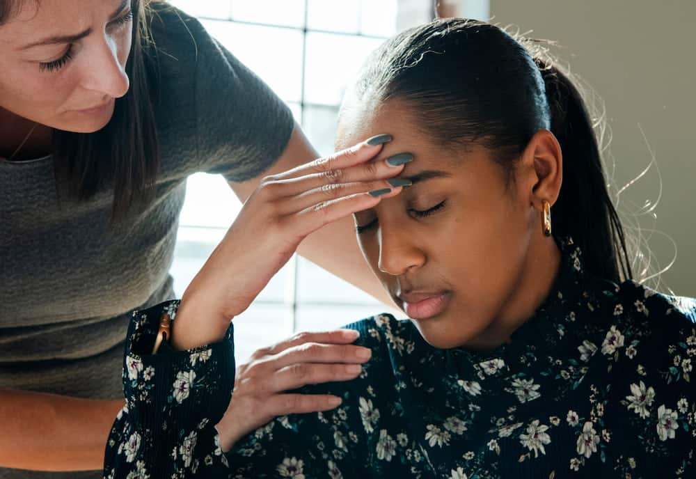 doctor assisting a female patient with headache