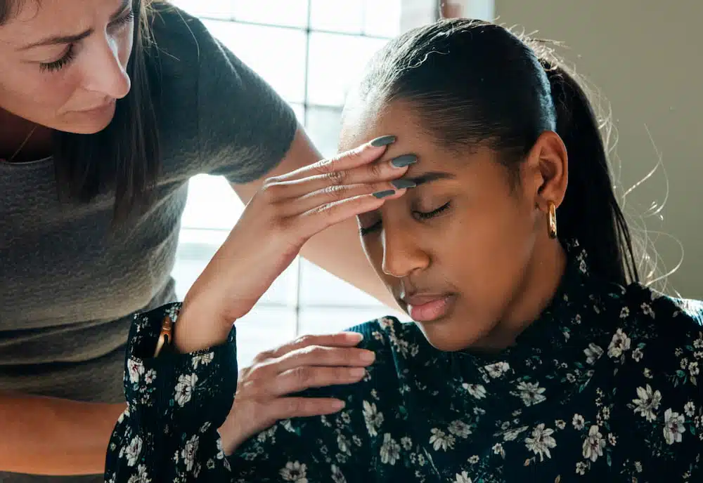 doctor assisting a female patient with headache