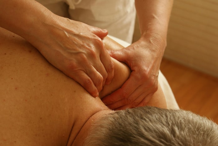 Myofascial Release Techniques used by therapist to a male patient's back