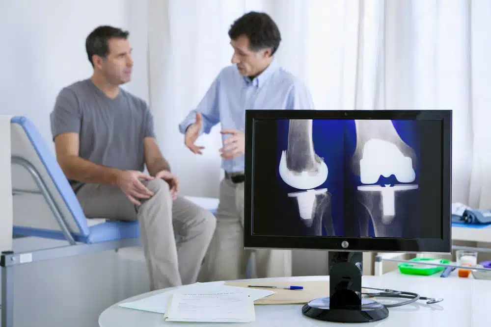 Patient having a consultation with a chiropractor after his knee Xray
