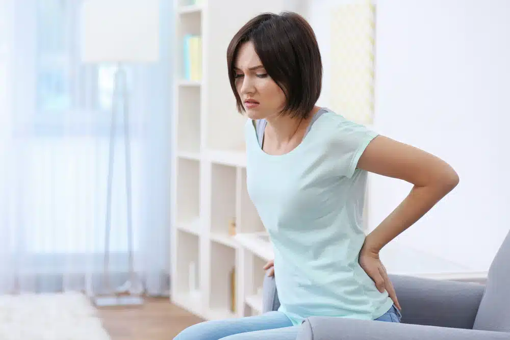 Woman suffers from low back pain due to poor posture