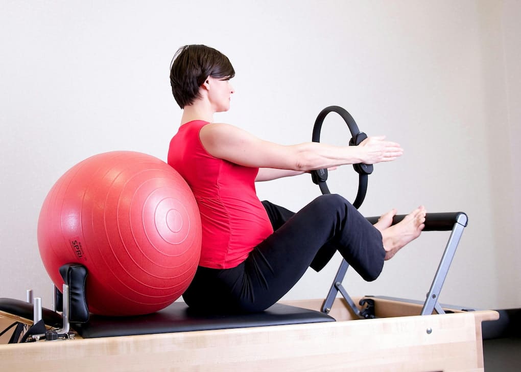 Pregnant woman doing some Prenatal care exercise at the chiropractor clinic