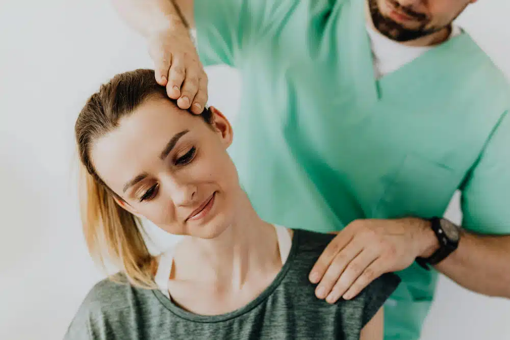 Woman with neck pain having chiropractic treatment at the clinic
