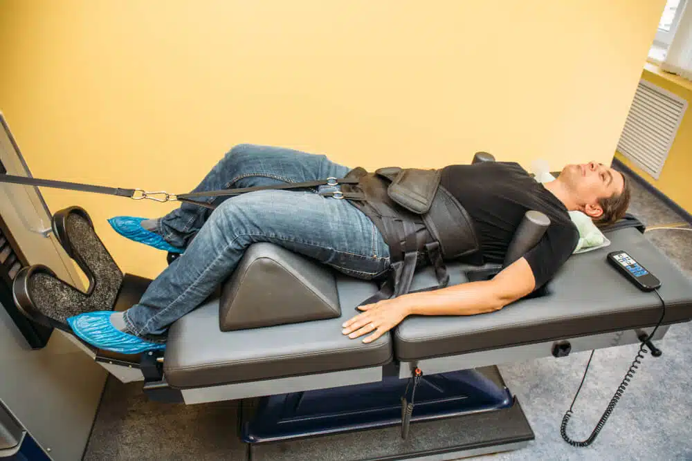 A patient lying in a bed under goes spinal decompression session.